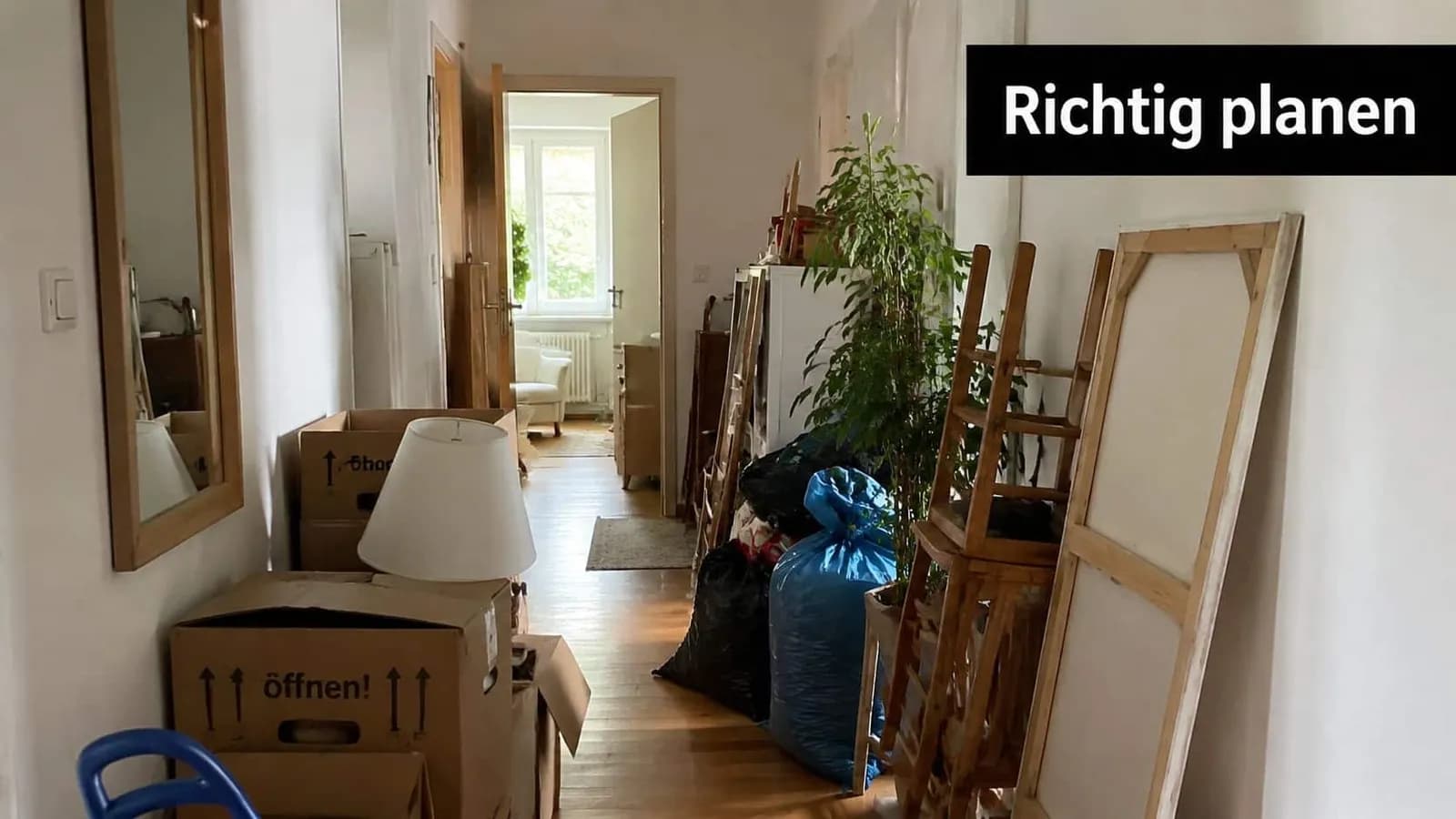 Ein enger Flur in einer Wohnung voller Umzugskartons, Müllsäcke und Gegenstände, die für die Entsorgung bereitstehen.