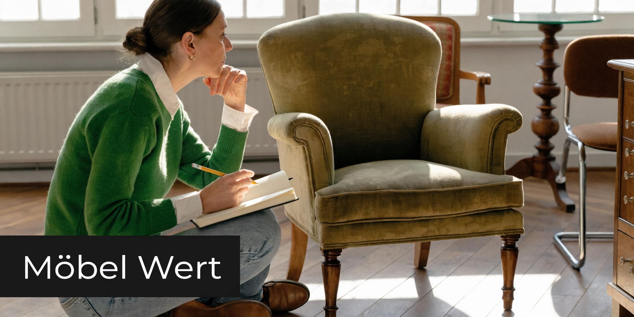 Eine Frau in einem grünen Pullover notiert Informationen bei der Begutachtung eines alten, grünen Polstersessels zur Wertermittlung.