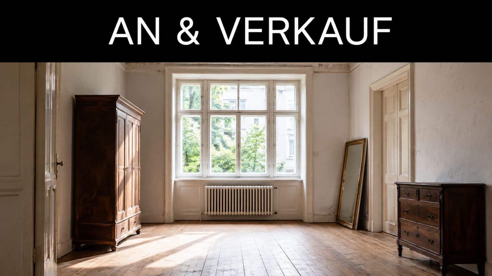 Ein heller, unmöblierter Raum mit hohen Fenstern, einer hölzernen Garderobe und einer Kommode in einer Altbauwohnung.